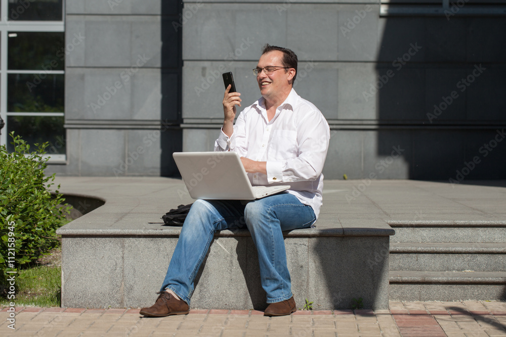 Adult man with computer and mobile phone Adult man with computer and mobile phone