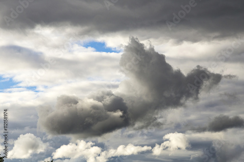 Cumulus Clouds And Grey Storm Clouds Gathering On Blue Sky