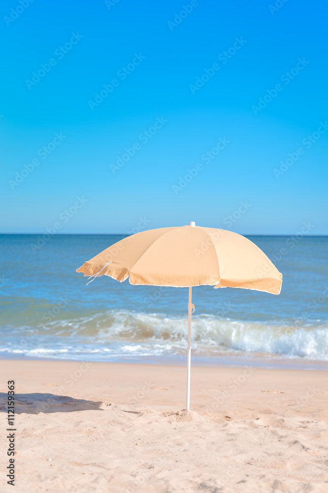 Sun parasol on the sandy beach ocean sky