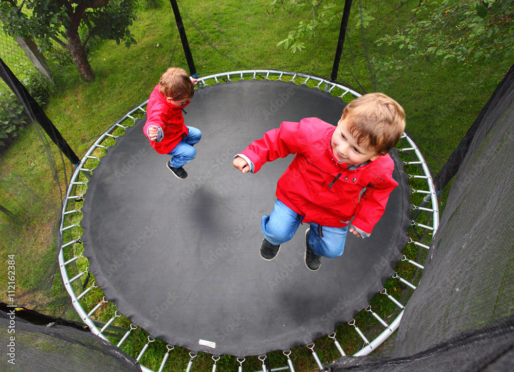 Funny kids playing and jumping on a outdoor trampoline. Children enjoying  life. Vacations on countryside. Healthy lifestyle. Stock Photo | Adobe Stock