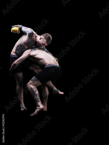 Mixed martial artists fighting on black background
