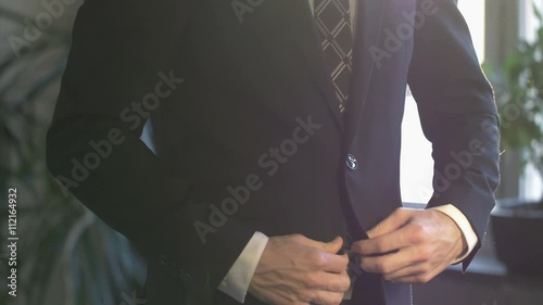 Elegant business man in white shirt buttoning his suit jacket. close up