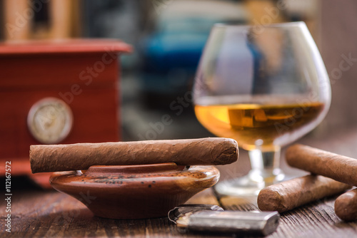 cigar and cognac with humidor in background © marcin jucha
