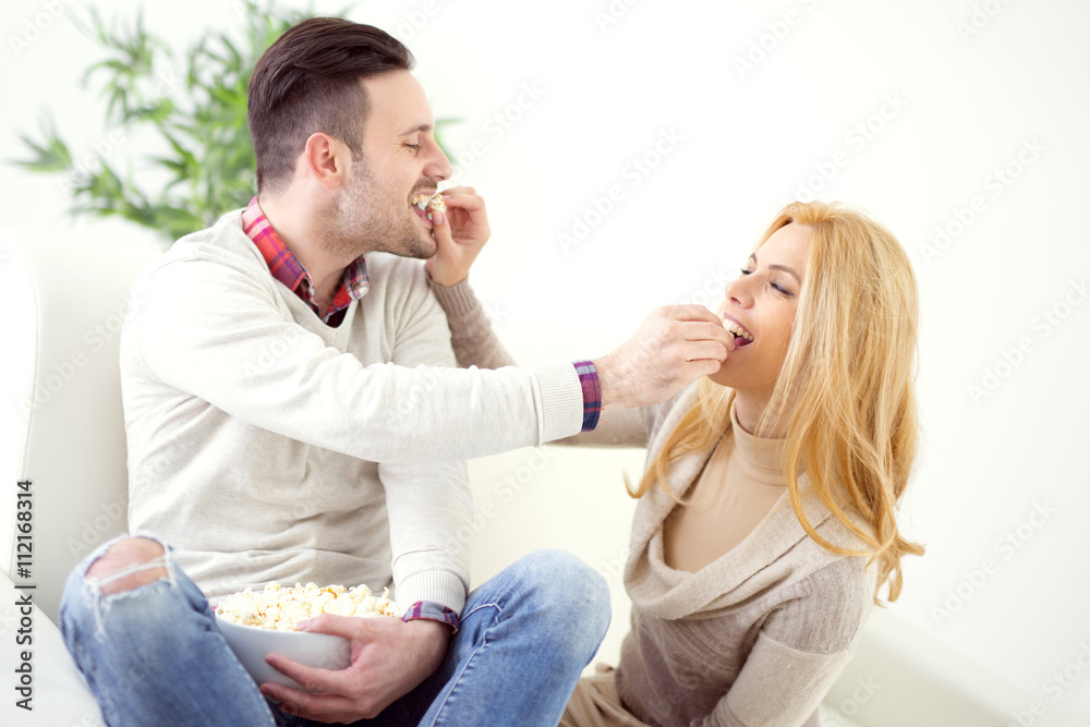 Cheerful couple eating popcorns Cheerful couple eating popcorns
