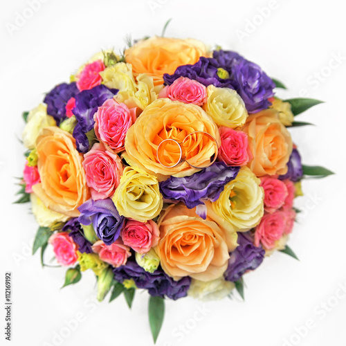 colorful rose bouquet with golden wedding rings 