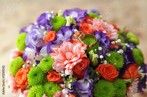colorful wedding bouquet with golden rings