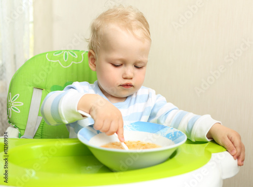 Cute little child eating blended carrot