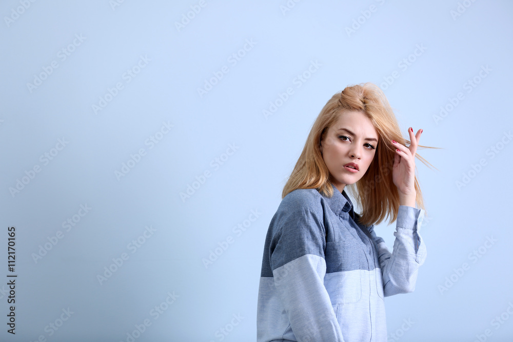 Beautiful young woman in shirt on blue wall background Beautiful young woman in shirt on blue wall background