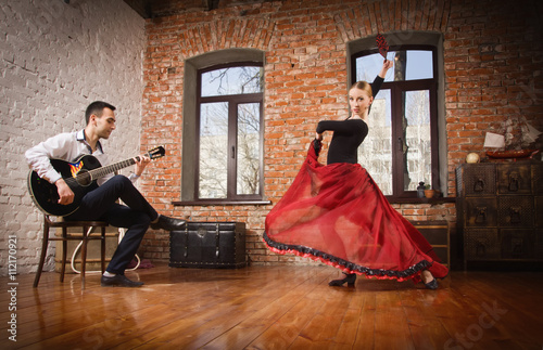 Young woman dancing flamenco and a man playing the guitar photo