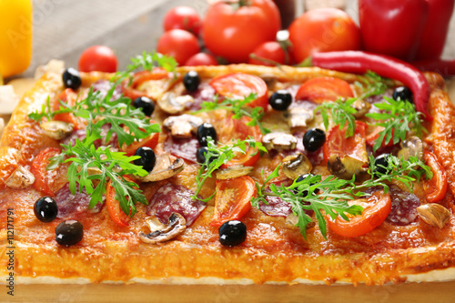 Rectangle delicious pizza and vegetables on the table, close-up