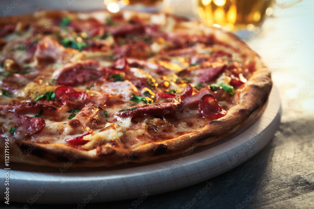 Delicious pizza  and glasses of beer are on wooden table, close up