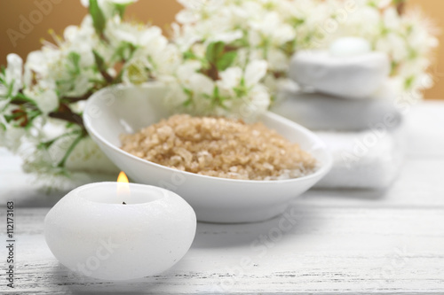 Spa treatment with blooming branch on white wooden table