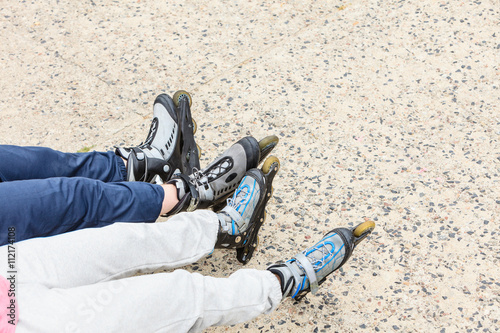 Closeup of people friends with roller skates.