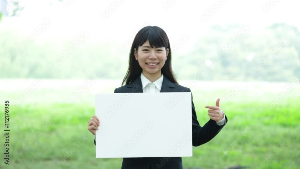 ボードを持つスーツの女性