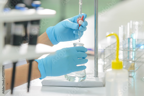 The woman who’s the scientist is demonstrate the titration tec