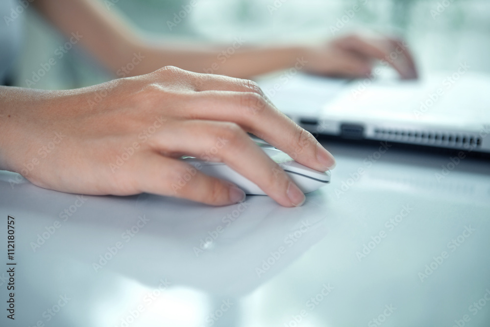 Female hand with computer mouse on table Female hand with computer mouse on table