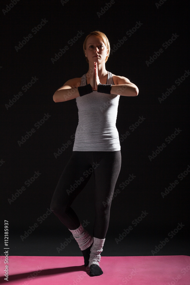 Young woman practicing yoga, Garudasana / Eagle pose Young woman practicing yoga, Garudasana / Eagle pose