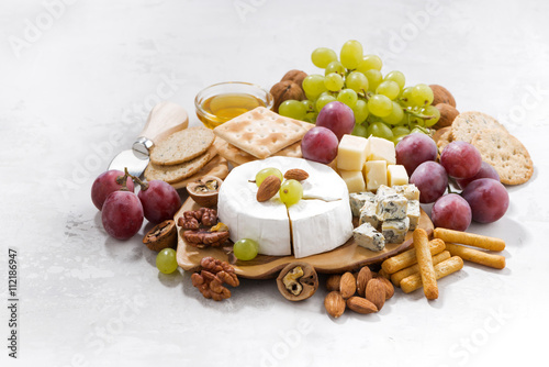 camembert, grapes and snacks on a white background