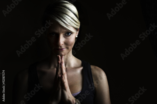 Lowkey Portrait von einer Frau mit gefallteten Haenden