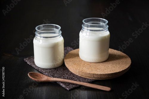 natural yogurt in a jar on the dark background