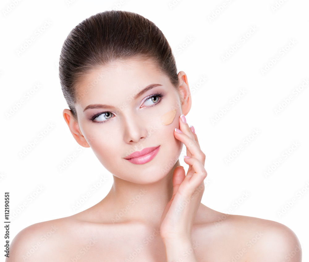 Beautiful young woman with cosmetic foundation on a skin.