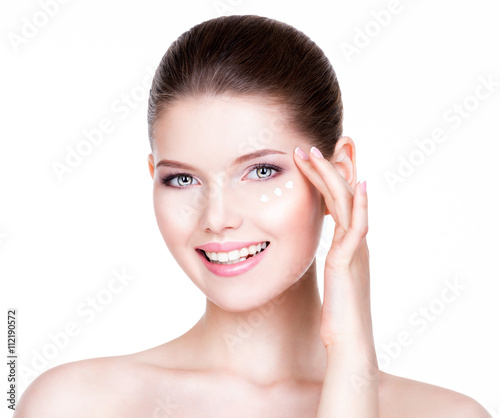 Woman with healthy face applying cosmetic cream.