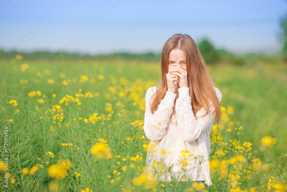 Pollen allergy, girl sneezing in a rapeseed field of flowers. Pollen allergy, girl sneezing in a rapeseed field of flowers.