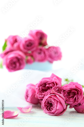 Beautiful pink roses on a white wooden table