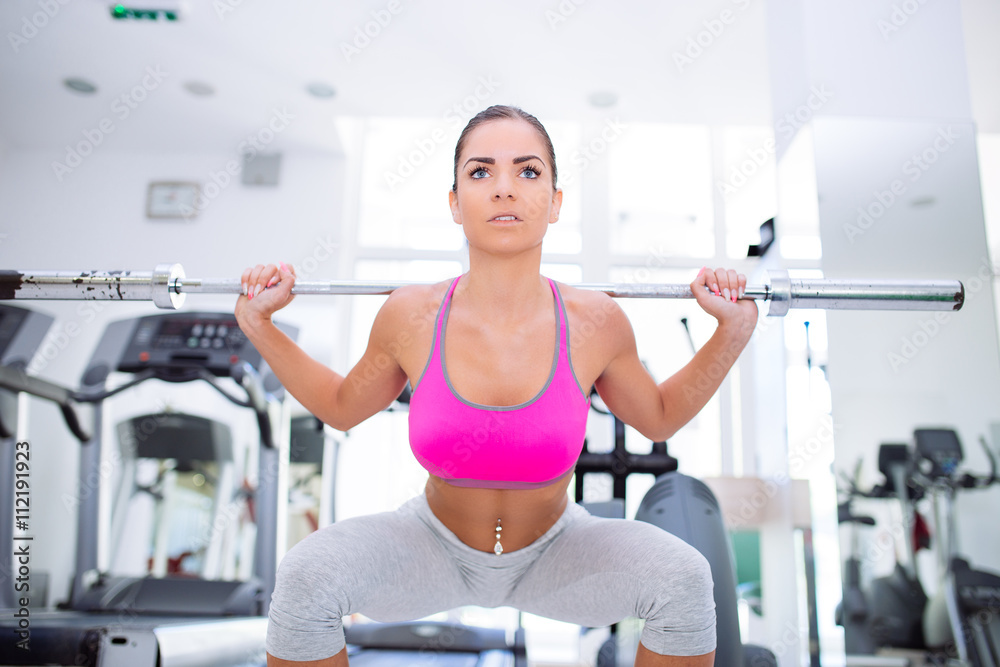 Beautiful and attractive young woman doing exercises at fitness gym. Beautiful and attractive young woman doing exercises at fitness gym.
