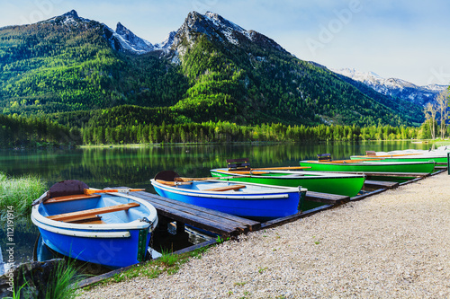 Moored boats on the lake with snowy alpine peak in the backgroun