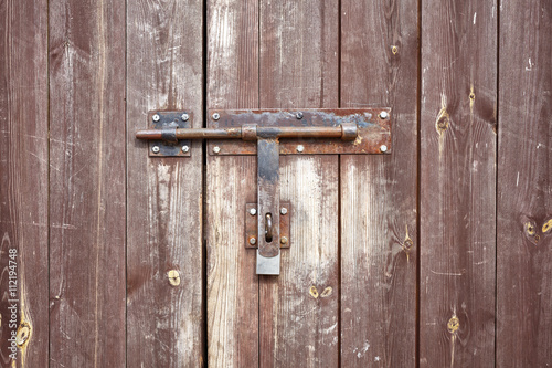 Old metal hasp on old wooden door.