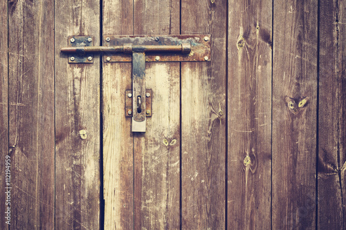Fotografia Vintage stylized old metal hasp on wooden door.