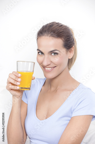 Young beautiful smiling woman with glass of orange juice