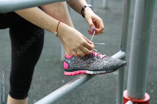 Sporty woman tie shoe laces, close up view