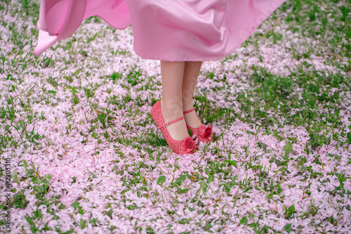 Fotografie Feet of small girl on grass with petals