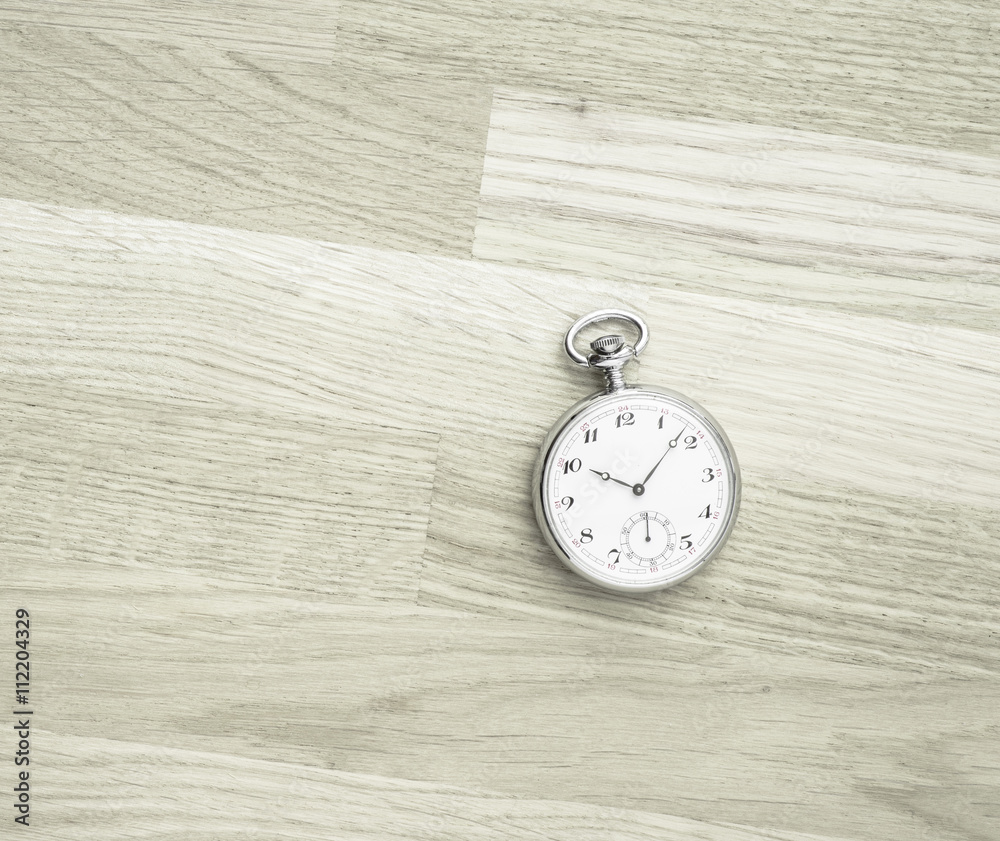 Pocket watch lying on wood table from above. Vintage timepiece still life. Concept of time, deadline and nostalgia. Pocket watch lying on wood table from above. Vintage timepiece still life. Concept of time, deadline and nostalgia.