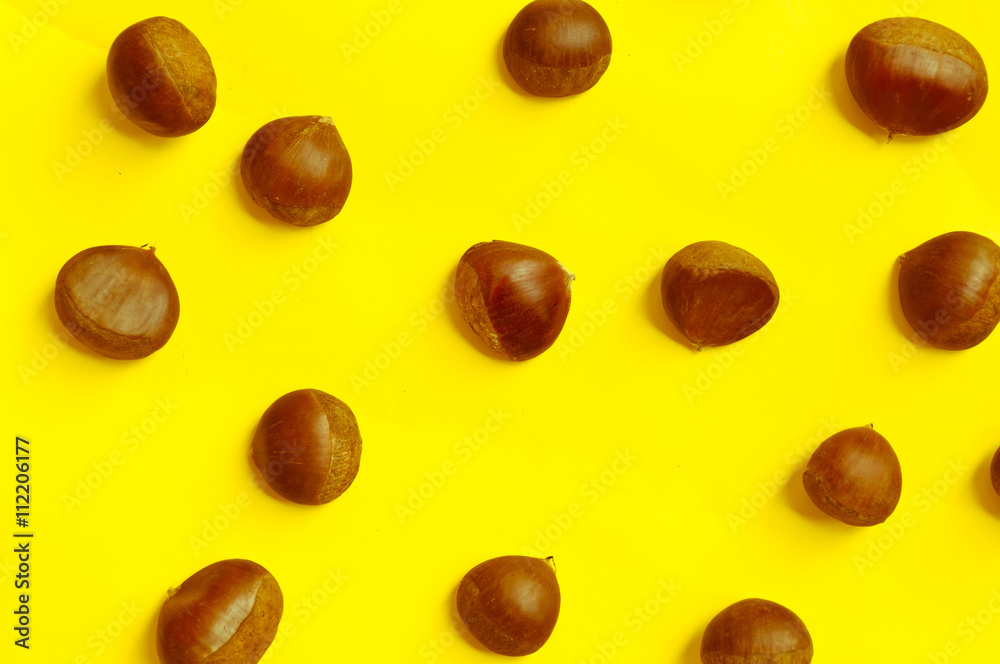 Chestnuts pattern on yellow background top view chestnut