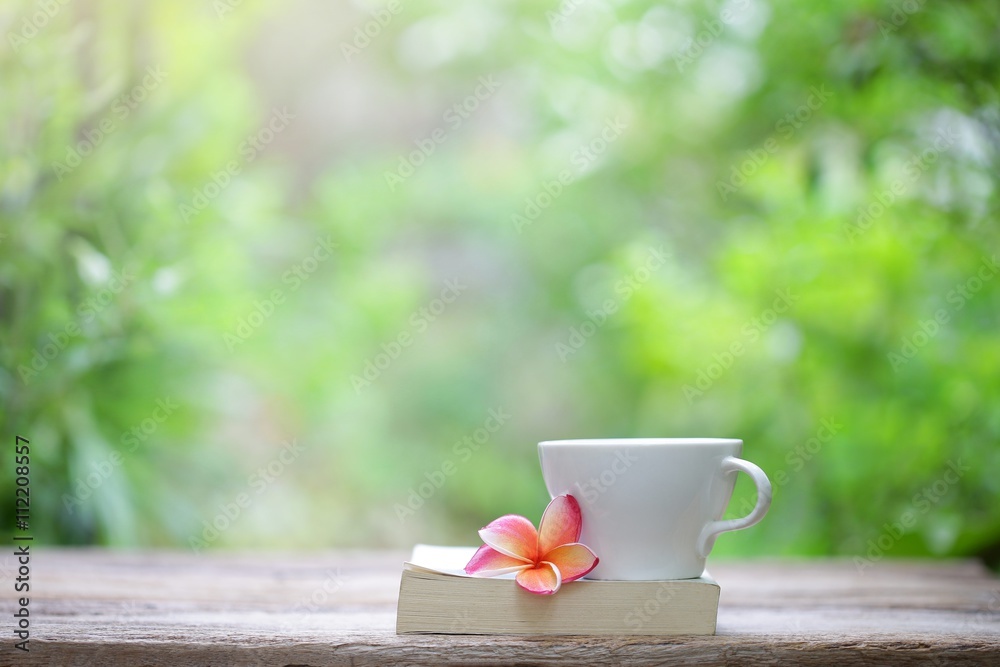 Notebook and cup with flower on wooden table Notebook and cup with flower on wooden table