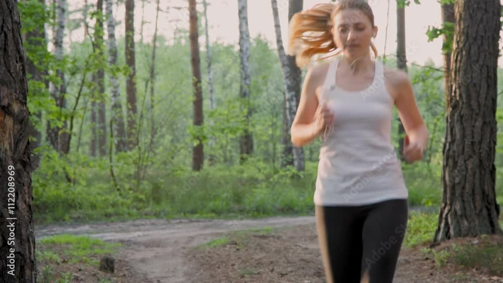 Young woman running in the morning in the forest, slow motion Young woman running in the morning in the forest, slow motion