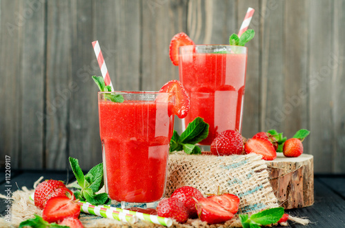 
Summer refreshing healthy drink , strawberry smoothie or fresh  with mint on a wooden background