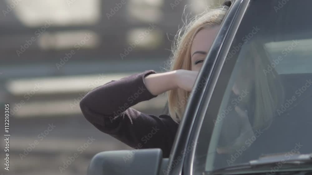 Blond girl taking photos from window with professional camera in old dodge car Blond girl taking photos from window with professional camera in old dodge car