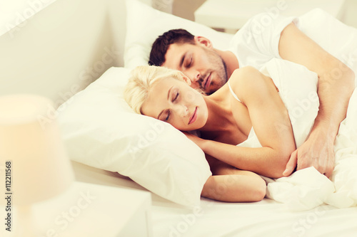 happy couple sleeping in bed at home