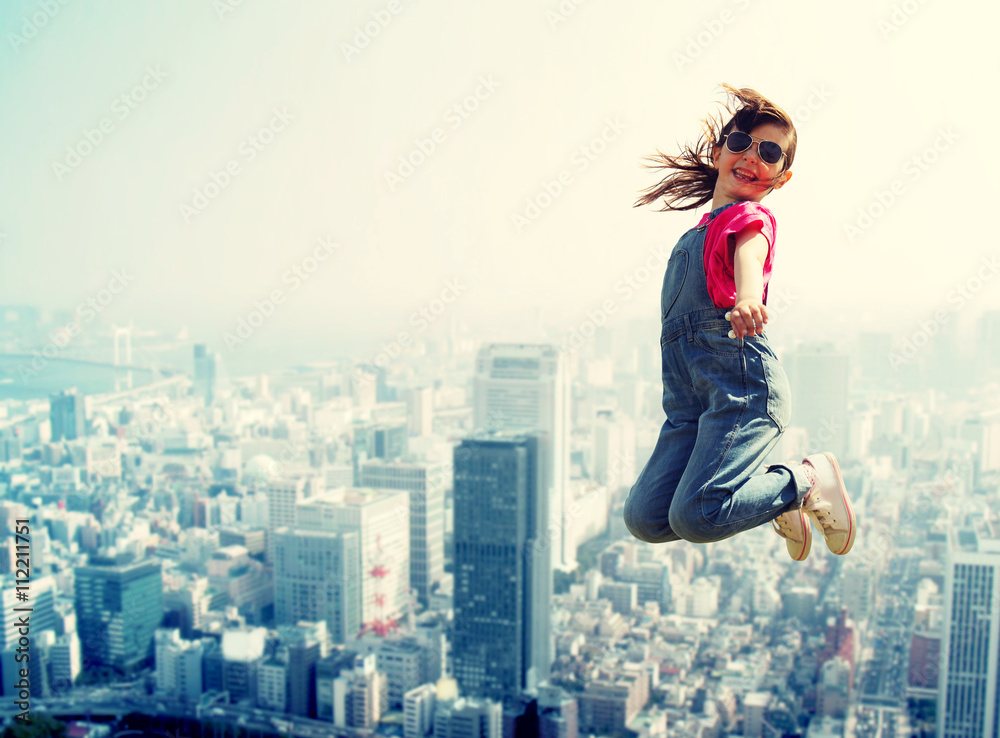 happy little girl jumping over city background happy little girl jumping over city background