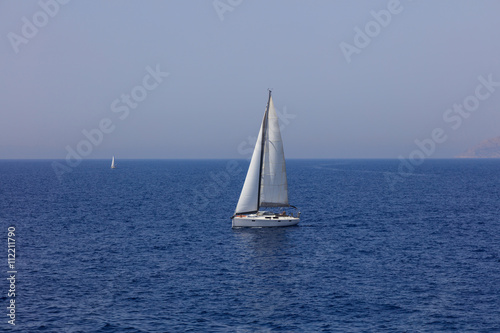 White sailing boat floating in sea