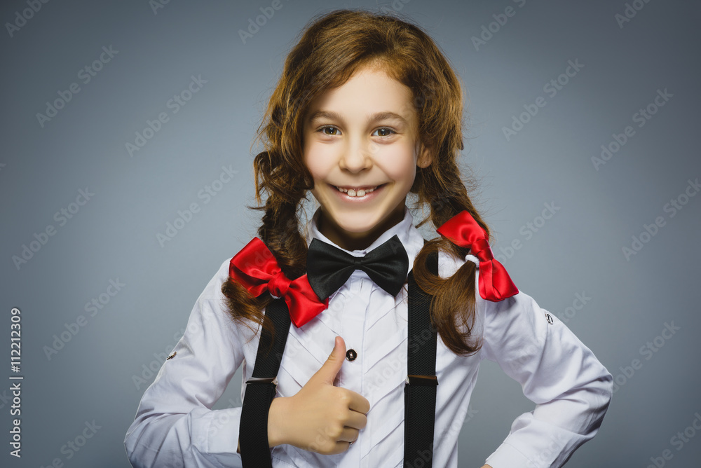 Happy girl. Closeup Portrait of handsome teen in casual shirt smiling show thumb up on grey background Happy girl. Closeup Portrait of handsome teen in casual shirt smiling show thumb up on grey background