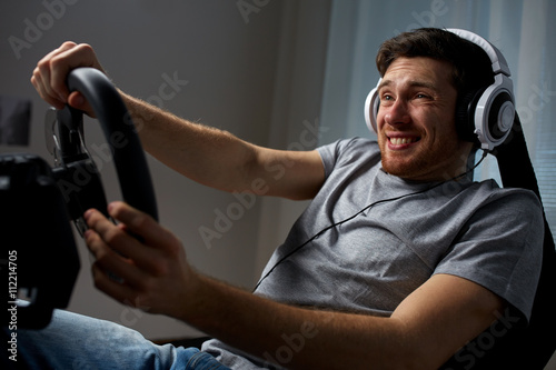 man playing car racing video game at home