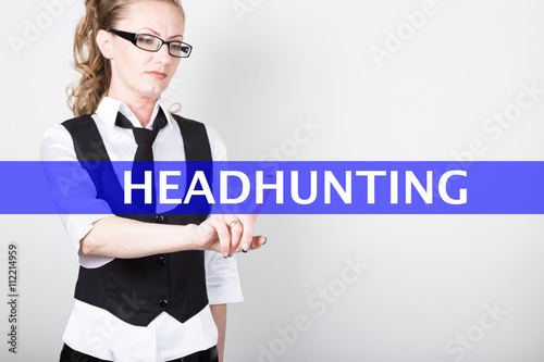 headhunting written on a virtual screen. Internet technologies in business and tourism. woman in business suit and tie, presses a finger on a virtual screen