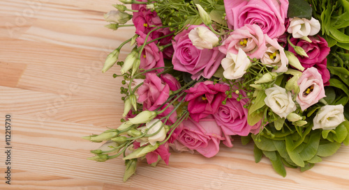 Picture of beautiful bouquet of flowers of pink or white roses represented on wooden background or table. Copyspace for your ideas or emotions to people in love.