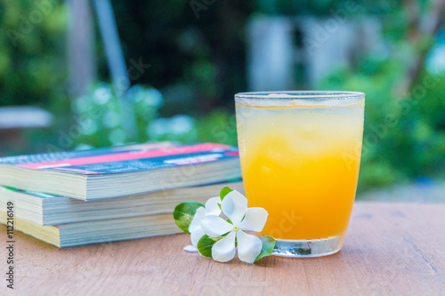 Glass of juice and books on the wooden table
