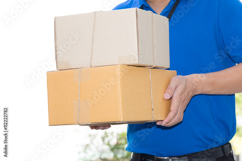 Delivery man holding a parcel box © comzeal